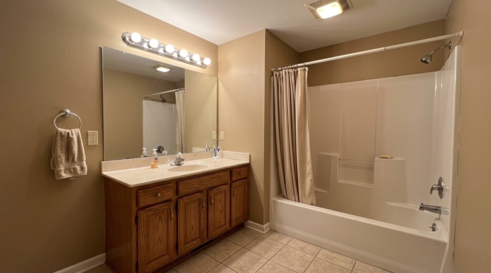 Antes: el mismo baño con mueble de roble anticuado y tina con cortina